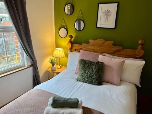 een slaapkamer met een wit bed en een groene muur bij Cosy Cottage in Central Reading Free Parking & Fast Wifi in Reading