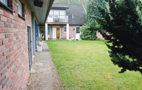 a house with a grass yard next to a building at Lovely Home In Nybrostrand With Sauna in Glemminge