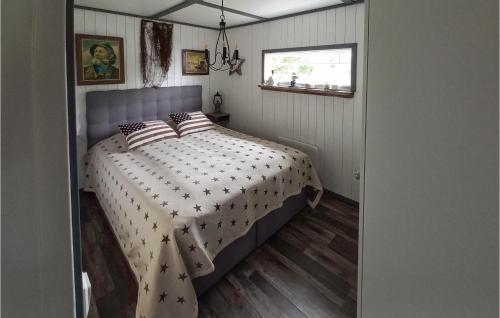 a bedroom with a bed with a comforter on it at Nice Home In Vstervik With 2 Bedrooms And Wifi in Västervik