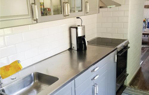 - une cuisine avec un évier et une cafetière sur un comptoir dans l'établissement Nice Home In Vstervik With 2 Bedrooms And Wifi, à Västervik