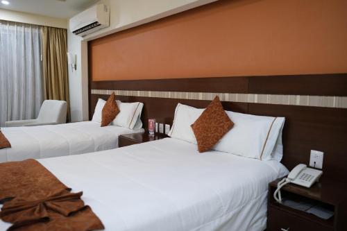 Habitación de hotel con 2 camas y teléfono en Ivissa Hotel en Santiago Pinotepa Nacional
