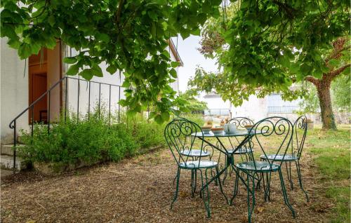 a table and chairs under a tree in a yard at La Haie in Les Montils
