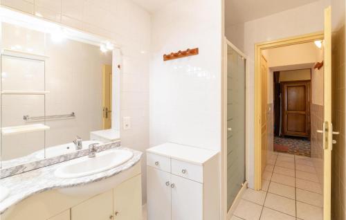 Baño blanco con lavabo y espejo en La Haie, en Les Montils