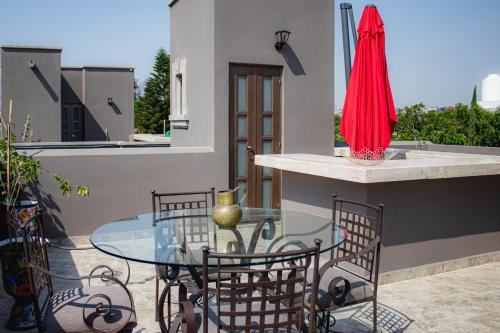 a glass table and chairs on a patio at BELLAS VILLAS VILLA SOL HERMOSA CASA y ACCECIBLE PRECIO in San Miguel de Allende