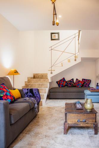 a living room with a couch and stairs at BELLAS VILLAS VILLA SOL HERMOSA CASA y ACCECIBLE PRECIO in San Miguel de Allende