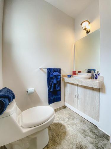 a bathroom with a white toilet and a sink at BELLAS VILLAS VILLA SOL HERMOSA CASA y ACCECIBLE PRECIO in San Miguel de Allende