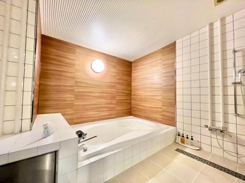 a bathroom with a bath tub and a sink at SKY Tower Sweet 4 Beppu, Resort Love Hotel in Beppu