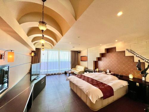 a hotel room with a large bed and a staircase at SKY Tower Sweet 4 Beppu, Resort Love Hotel in Beppu