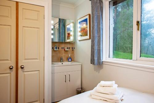 a bathroom with a sink and a window and towels at 5 bed house near Oban in Oban