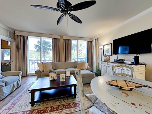 een woonkamer met een bank en een plafondventilator bij Gulf Place Six Palms #2B - BBs Hideaway in Santa Rosa Beach