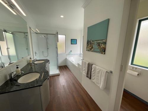 a bathroom with a sink and a tub at Luxury Home Next to Ocean and Walkway in New Plymouth