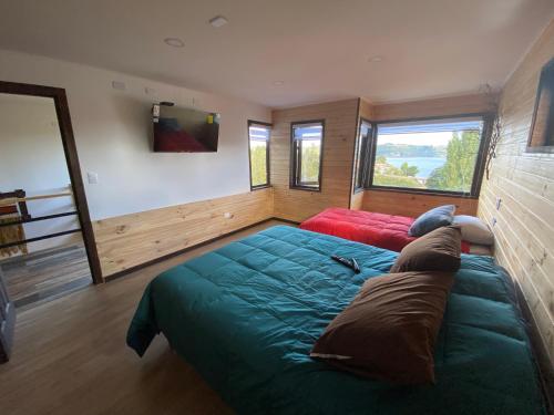 een slaapkamer met een bed en een bank erin bij Cabañas y hostal Aurora in Castro