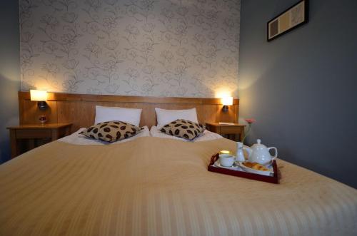 a bed with two pillows and a tray of food on it at Hotel - Restaurant Gonduzo in Odorheiu Secuiesc