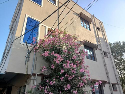 budynek z różowymi kwiatami przed nim w obiekcie ADVIK HOMESTAYS w mieście Tirupati
