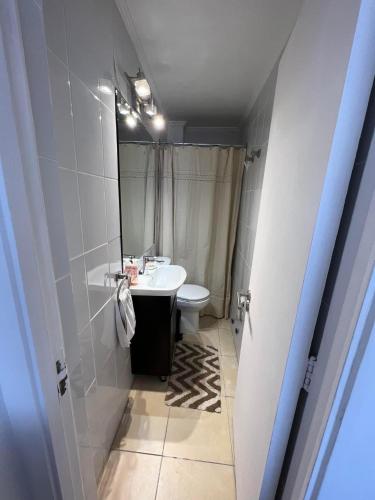 a bathroom with a white sink and a toilet at Departamento en Edificio Hanga Roa - Frente Muelle Vergara in Viña del Mar