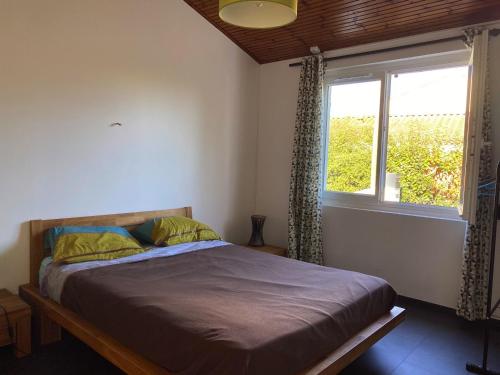 une chambre avec un lit et une fenêtre dans l'établissement Maison à Jard-sur-Mer, 500m de la Plage, 2 Chambres, Climatisation, Parking et Jardin Clôturé - FR-1-336-124, à Jard-sur-Mer
