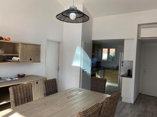 une cuisine et une salle à manger avec une table et des chaises en bois dans l'établissement Maison à Jard-sur-Mer, 500m de la Plage, 2 Chambres, Climatisation, Parking et Jardin Clôturé - FR-1-336-124, à Jard-sur-Mer