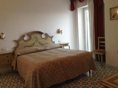 a bedroom with a large bed with a brown blanket at Hotel Lidomare in Amalfi