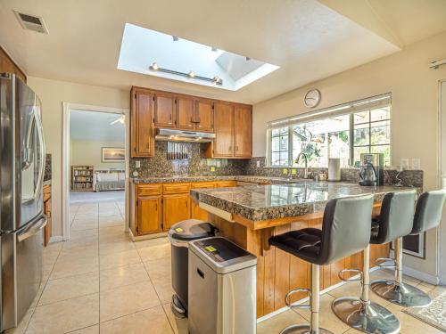 a kitchen with wooden cabinets and a island with bar stools at Amazing Santa Cruz Landscaped Paradise in Santa Cruz