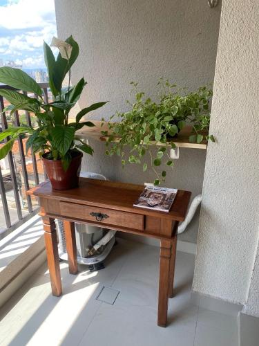 a wooden table with potted plants on a balcony at São Paulo - Vila Mariana - Central in Sao Paulo