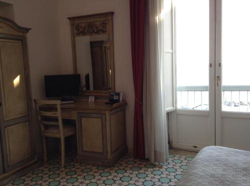 a bedroom with a desk with a computer and a window at Hotel Lidomare in Amalfi