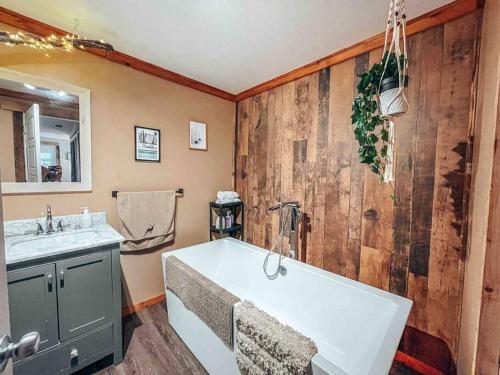ein Badezimmer mit einer großen weißen Badewanne und einem Waschbecken in der Unterkunft Logement Mandala tout équipé in Saint Mathieu Du Parc