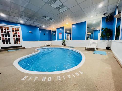 uma grande piscina num quarto com paredes azuis em Inn of the Dove - Romantic Luxury Suites with Jacuzzi & Fireplace at Harrisburg-Hershey-Philadelphia, PA em Harrisburg