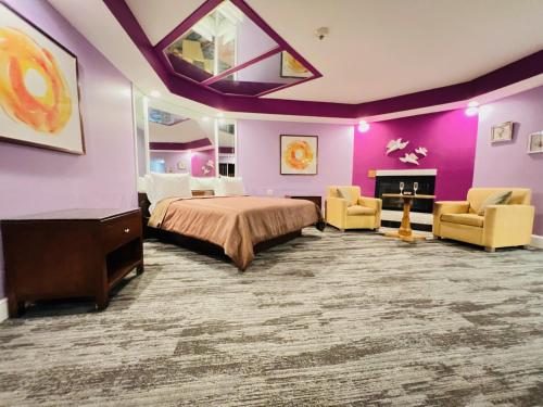 a bedroom with purple walls and a bed and two chairs at Inn of the Dove - Romantic Luxury Suites with Jacuzzi & Seasonal Fireplace at Harrisburg-Hershey-Philadelphia, PA in Harrisburg