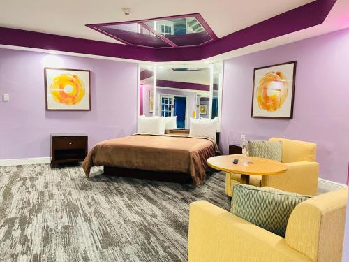 a hotel room with a bed and a couch and a table at Inn of the Dove - Romantic Luxury Suites with Jacuzzi & Seasonal Fireplace at Harrisburg-Hershey-Philadelphia, PA in Harrisburg