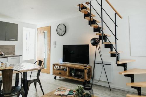 ein Wohnzimmer mit einem TV und einer Treppe in der Unterkunft la bohème in Cherbourg en Cotentin