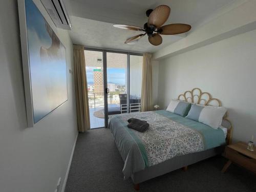 a bedroom with a bed and a ceiling fan at Townsville City Ocean View Apartment in Townsville