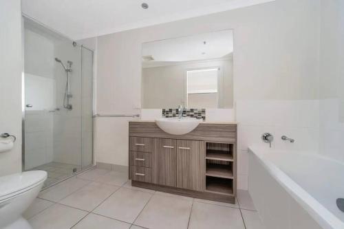 a bathroom with a sink and a toilet and a shower at Townsville City Ocean View Apartment in Townsville