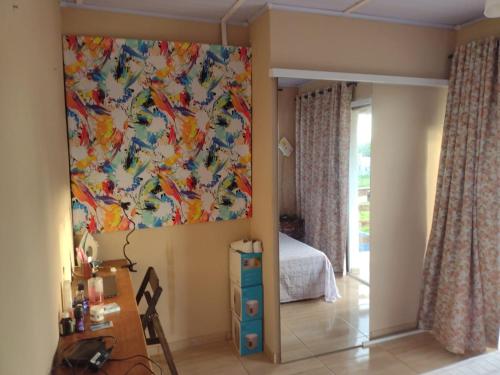 1 dormitorio con una gran pintura en la pared en Casa charmosa em ARMAÇÃO DOS BÚZIOS, en Búzios