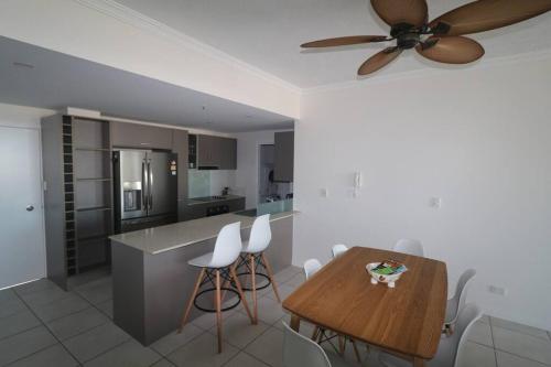 a kitchen with a table and a ceiling fan at Townsville City Ocean View Apartment in Townsville