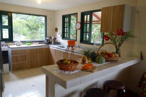 una cocina con 2 cestas de fruta en una barra en Alejandría, reserva natural y las 7 cascadas, en La Vega