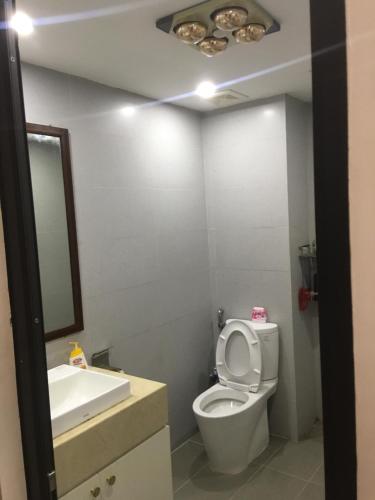 bagno con servizi igienici, lavandino e specchio di Happy House 1 a Hanoi