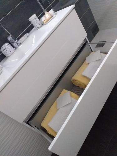 ein weißer Schrank mit zwei Kissen und einem Waschbecken in der Unterkunft Beausoleil near Monaco in Beausoleil
