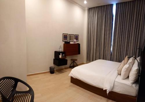 a bedroom with a bed and a chair and a window at S Loft Manado in Manado