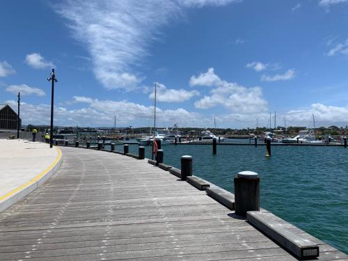 a dock with water and boats in a harbor at Pelicans Rest Shellharbour in Shellharbour