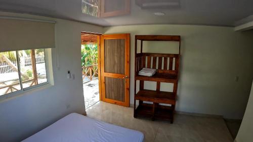 a room with a bedroom with a bed and a door at Coral Inn Providencia Isla in Providencia