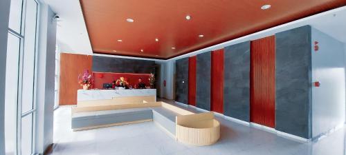 a lobby with a bar with red and gray walls at Front One Hotel Pasir Koja Bandung in Bandung