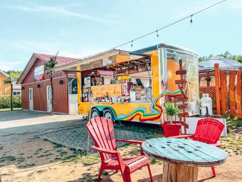 a table and two chairs and a food truck at Gîte B&B du Village in Saint Mathieu Du Parc