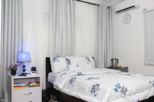 a bedroom with a bed with blue and white sheets at 1 Bedroom Entire APT - Kitchen - Wi-Fi in Ikeja