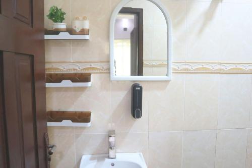 a bathroom with a sink and a mirror at 1 Bedroom Entire APT - Kitchen - Wi-Fi in Ikeja