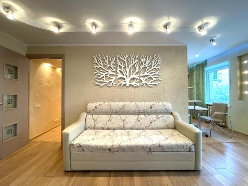 un soggiorno con divano e una parete con un dipinto di 2-х комн квартира с двухместным джакузи a Petropavlovsk