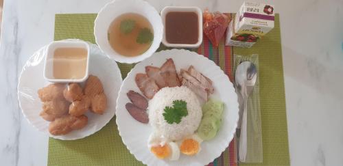 a plate of food with rice and meat and a bowl of soup at Na Cha Lae 1 ณ ชเล in Chanthaburi