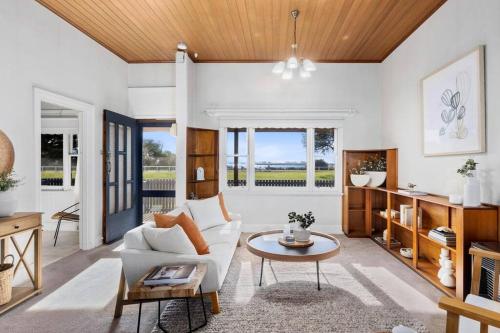 a living room with a white couch and a table at Swan View in Queenscliff