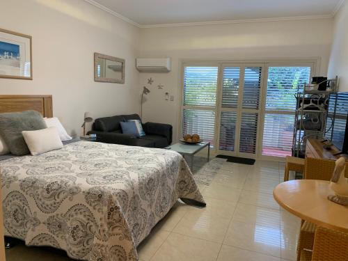 蜆殼港的住宿－貝殼港鵜鶘休閒公寓，一间卧室配有一张床、一把椅子和一张桌子