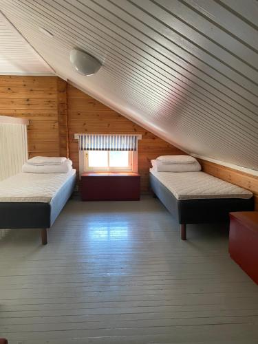 MatildedalにあるMeri-Ruukin Lomakyläのベッド2台と窓が備わる屋根裏部屋です。