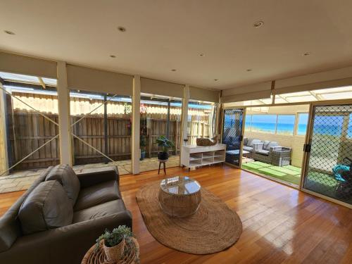 a living room with a couch and a table at Sandy Shores Estate- Long Island in Frankston